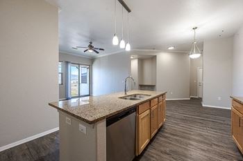 A kitchen with a granite countertop and stainless steel appliances